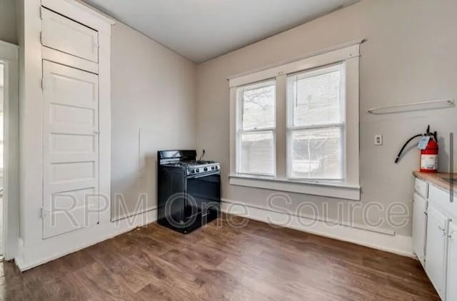 unfurnished room with dark wood-style flooring and baseboards