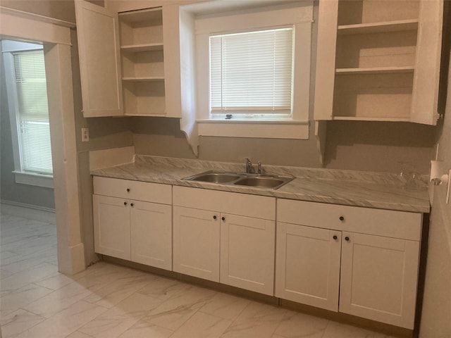 kitchen featuring marble finish floor, white cabinetry, open shelves, and a sink