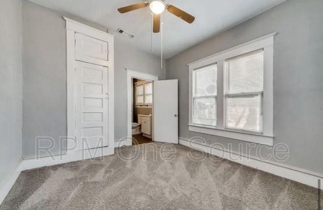 unfurnished bedroom with carpet, visible vents, connected bathroom, and ceiling fan