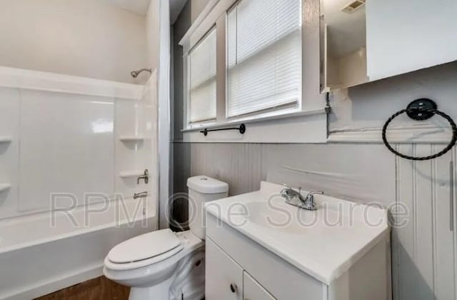 full bathroom with visible vents, toilet, a wainscoted wall, tub / shower combination, and vanity