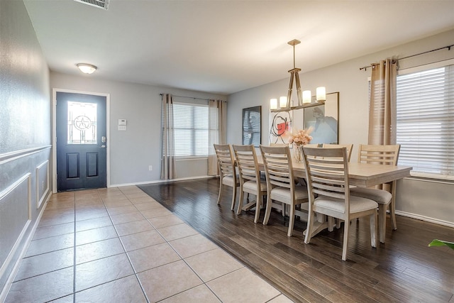 dining space featuring visible vents, baseboards, light wood-type flooring, and a chandelier