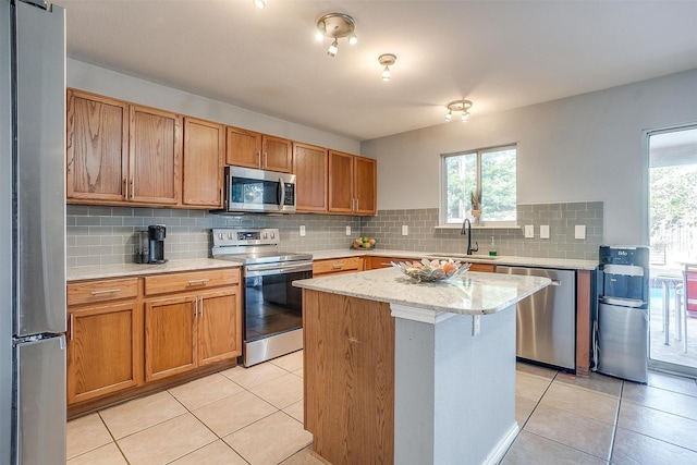 kitchen featuring light tile patterned floors, plenty of natural light, appliances with stainless steel finishes, and a sink