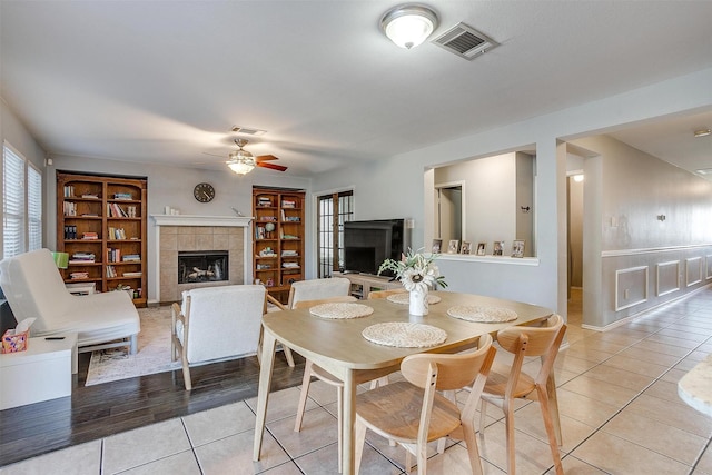 dining room with light tile patterned floors, visible vents, and a tile fireplace