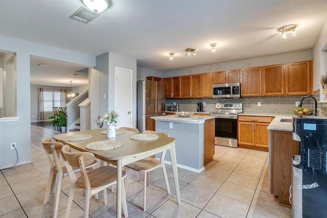 kitchen featuring visible vents, a sink, stainless steel appliances, light tile patterned flooring, and light countertops