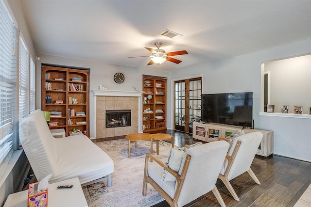 living room with plenty of natural light, wood finished floors, visible vents, and french doors