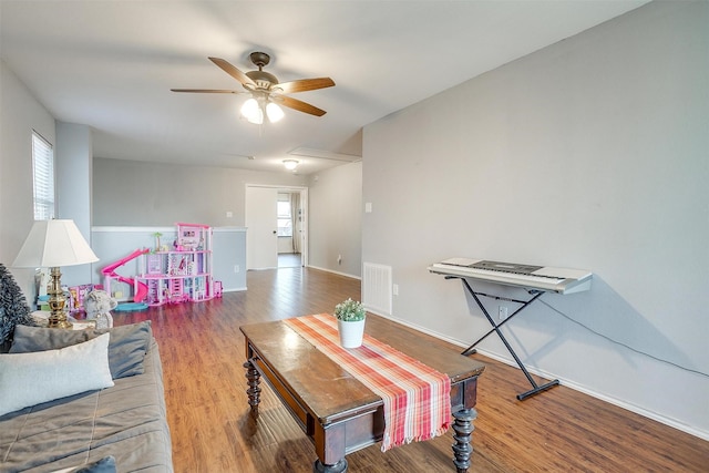 interior space featuring baseboards, wood finished floors, visible vents, and ceiling fan