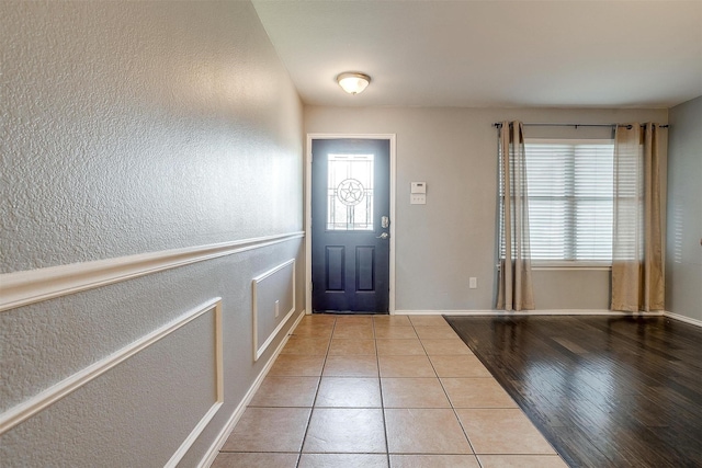 foyer entrance featuring a healthy amount of sunlight, wood finished floors, and a textured wall