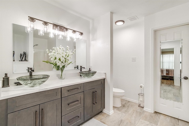 bathroom with visible vents, a sink, and double vanity