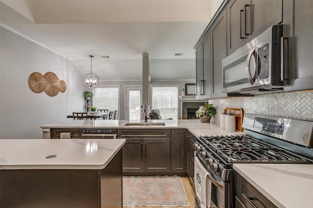 kitchen featuring decorative light fixtures, visible vents, backsplash, appliances with stainless steel finishes, and a sink