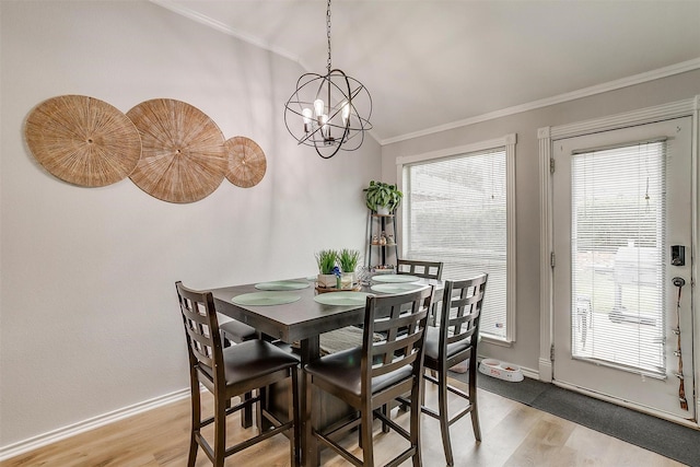 dining space with light wood-type flooring, a wealth of natural light, and crown molding