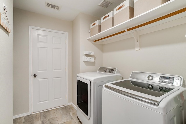 washroom featuring laundry area, visible vents, independent washer and dryer, and baseboards