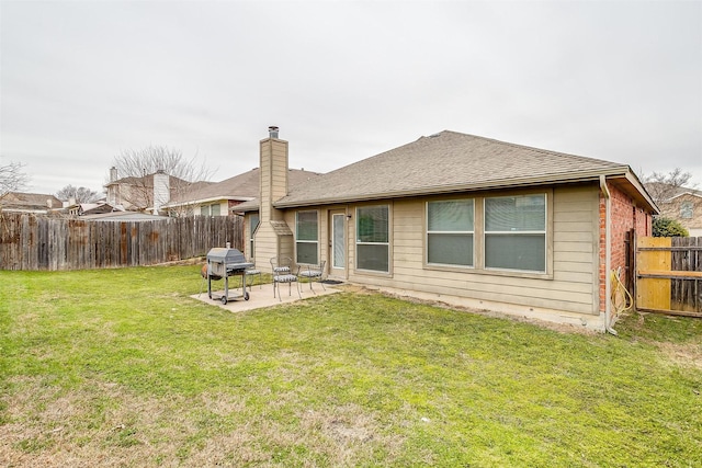 back of property featuring a patio area, a fenced backyard, a chimney, and a yard