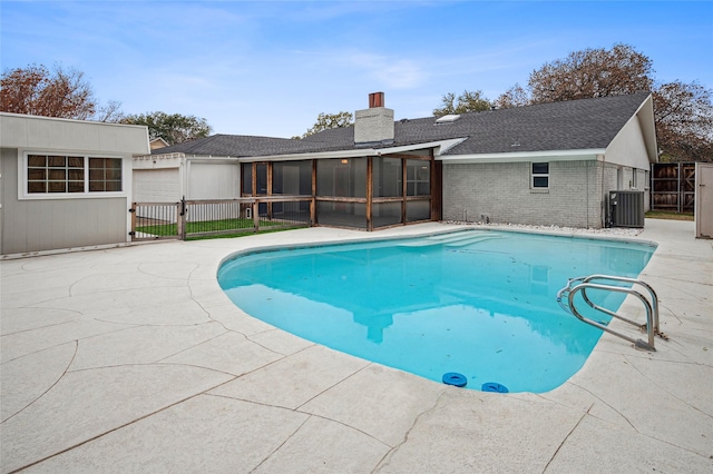 view of swimming pool with cooling unit, fence, a sunroom, and a fenced in pool