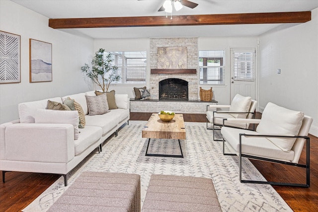 living room featuring beam ceiling, a fireplace, and wood finished floors