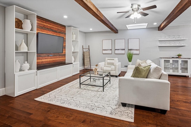 living area with a skylight, dark wood-type flooring, beam ceiling, and recessed lighting