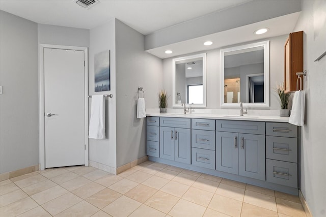 full bath featuring double vanity, baseboards, and a sink