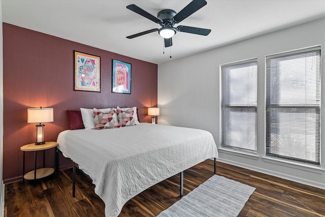 bedroom with dark wood-style floors, ceiling fan, and baseboards