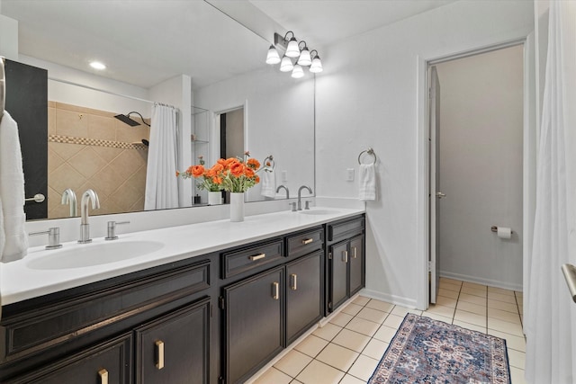 bathroom featuring double vanity, a sink, baseboards, and tile patterned floors