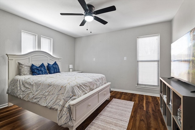 bedroom with multiple windows, dark wood finished floors, baseboards, and ceiling fan