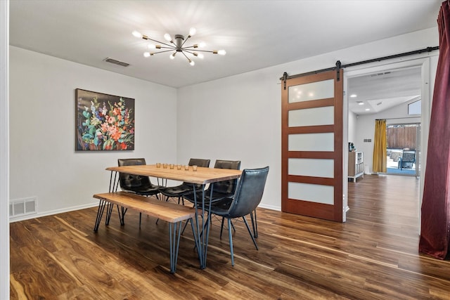 dining room featuring an inviting chandelier, a barn door, visible vents, and dark wood-type flooring