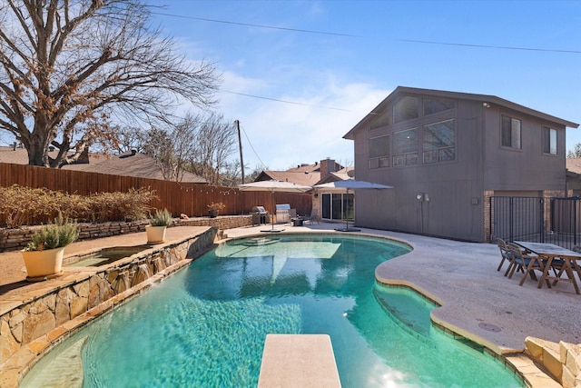 view of pool featuring a patio area, a fenced backyard, a diving board, and a fenced in pool