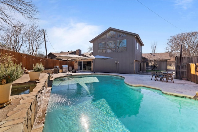 view of pool with grilling area, a patio area, a fenced backyard, and a fenced in pool