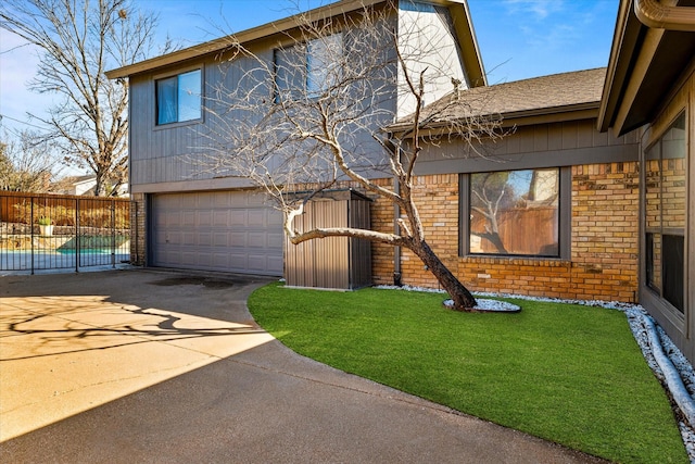 view of front of property with a front yard, concrete driveway, brick siding, and an attached garage