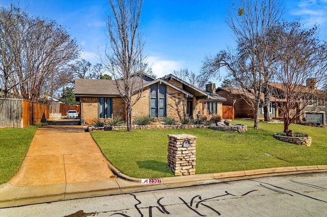 mid-century modern home featuring brick siding, concrete driveway, a front yard, a gate, and fence