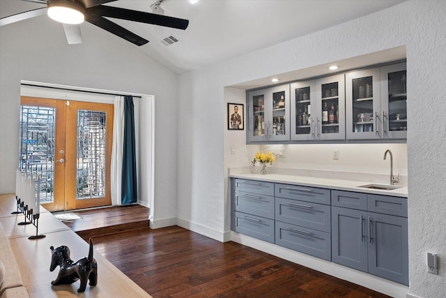 bar featuring lofted ceiling, dark wood-type flooring, a sink, visible vents, and french doors