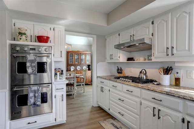 kitchen with light wood finished floors, under cabinet range hood, stainless steel appliances, white cabinetry, and open shelves