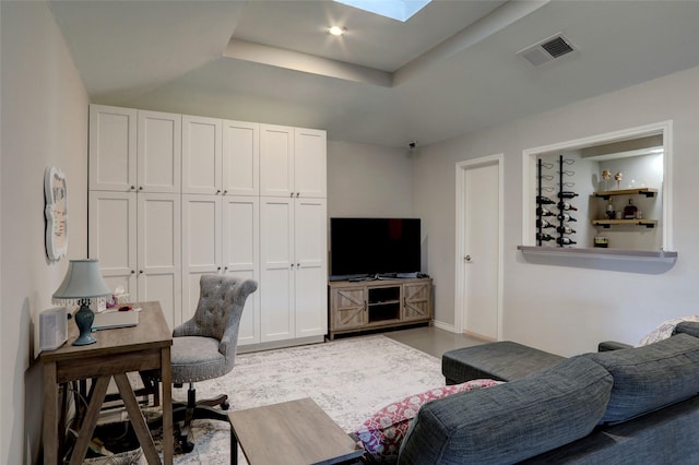 office area featuring a raised ceiling, a skylight, baseboards, and visible vents