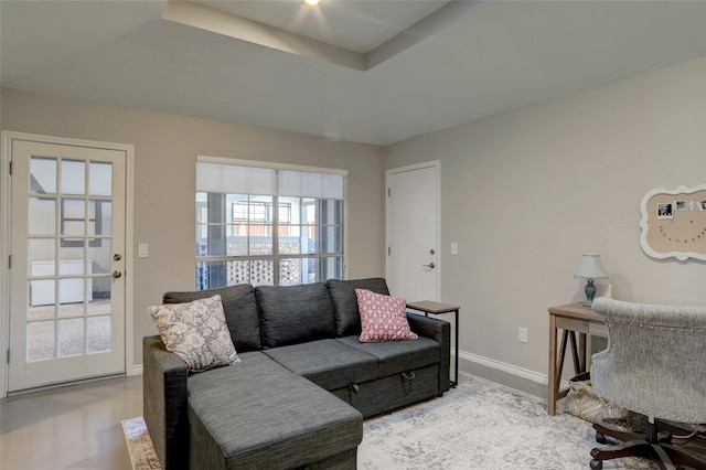 living area featuring baseboards and a tray ceiling