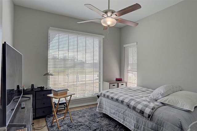 bedroom with ceiling fan, baseboards, and wood finished floors