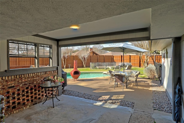 view of patio / terrace featuring outdoor dining space, a fenced in pool, and fence