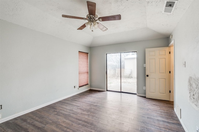 empty room featuring vaulted ceiling, wood finished floors, visible vents, and baseboards