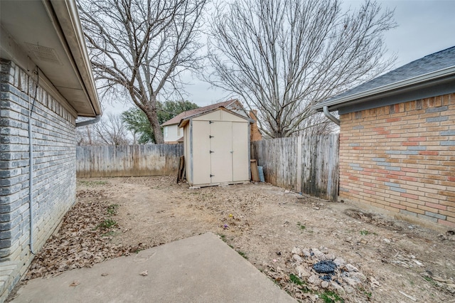 view of yard featuring an outbuilding, a fenced backyard, and a storage shed