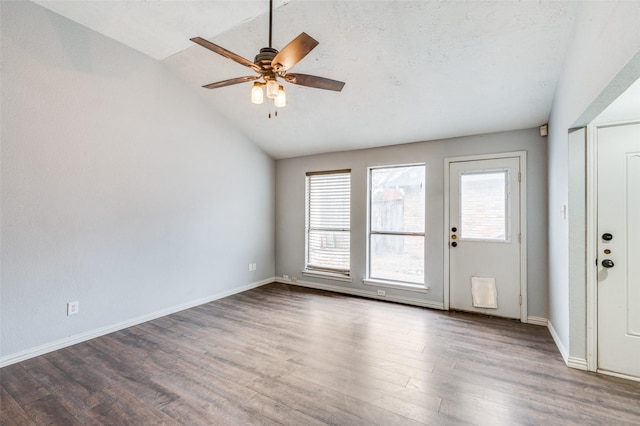 interior space with lofted ceiling, ceiling fan, baseboards, and wood finished floors