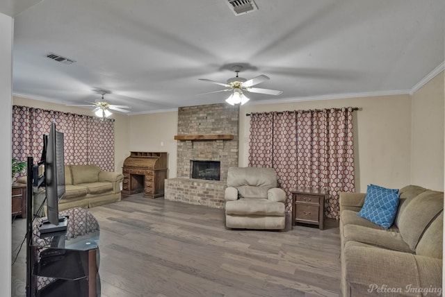 living room with visible vents, crown molding, and wood finished floors