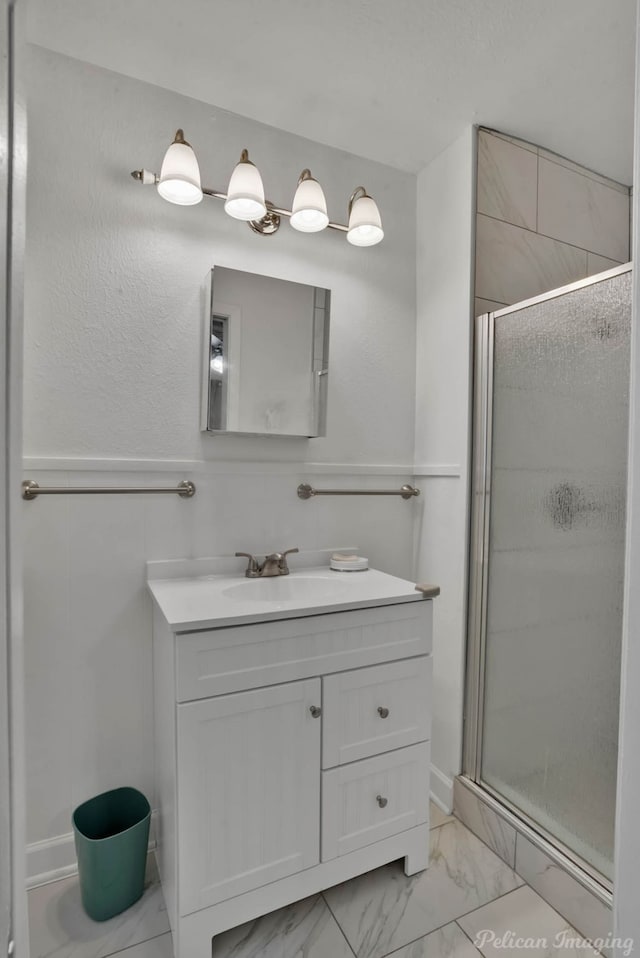 full bath with a stall shower, marble finish floor, and vanity