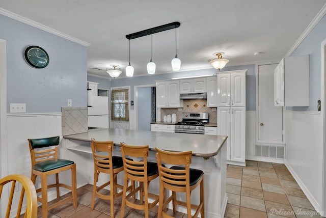 kitchen with visible vents, white cabinets, stainless steel range, and a peninsula