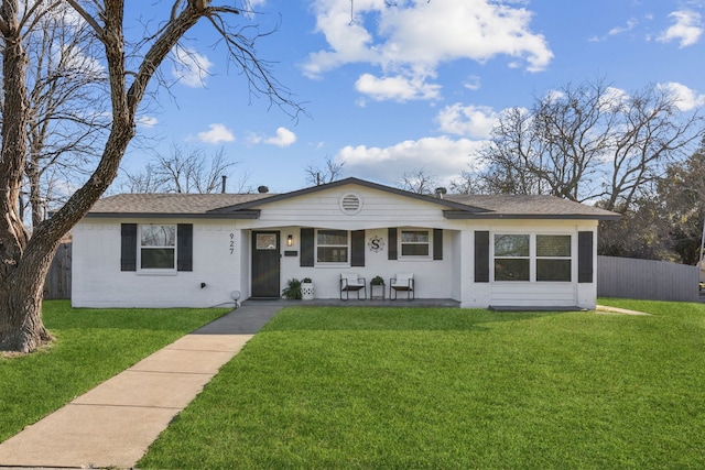 single story home featuring a front lawn, roof with shingles, fence, and brick siding