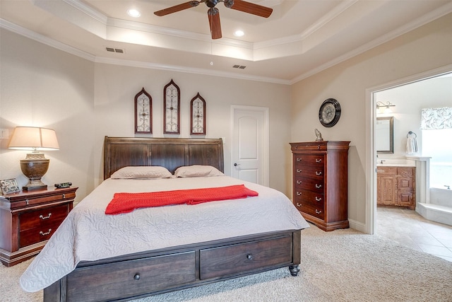 bedroom with a tray ceiling, visible vents, crown molding, and light carpet