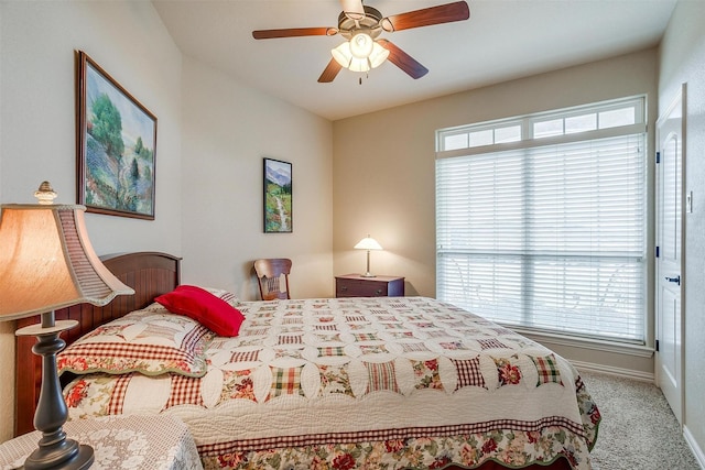 carpeted bedroom with a ceiling fan and baseboards