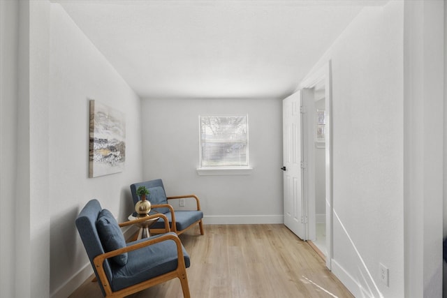 living area featuring light wood finished floors and baseboards