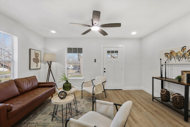 living room featuring baseboards, ceiling fan, recessed lighting, and light wood-style floors