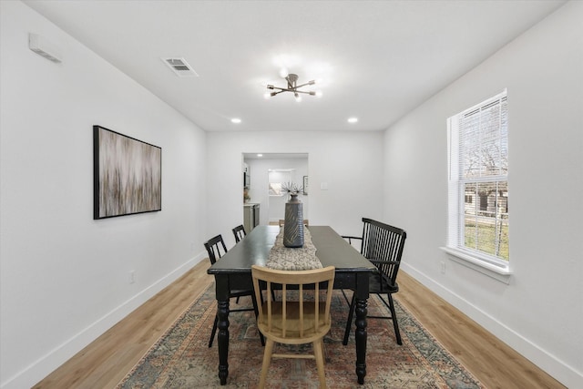 dining room with baseboards, visible vents, and light wood finished floors