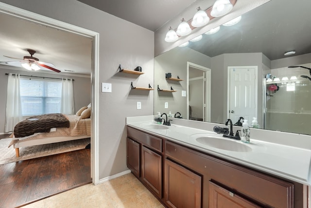 bathroom featuring ceiling fan, tile patterned flooring, a sink, and ensuite bathroom