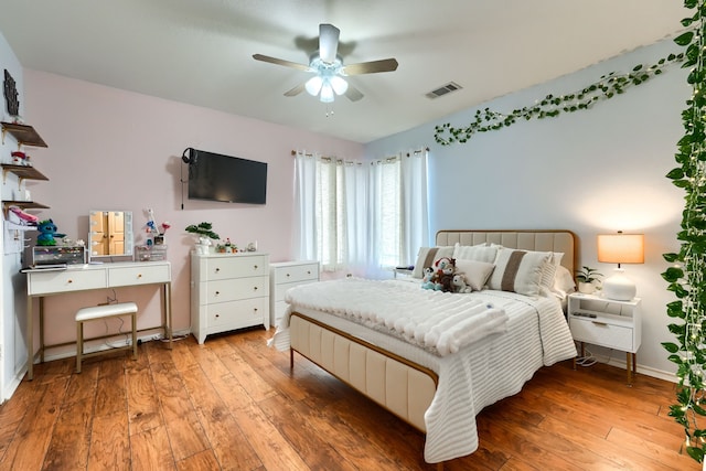 bedroom featuring light wood-style floors, visible vents, ceiling fan, and baseboards