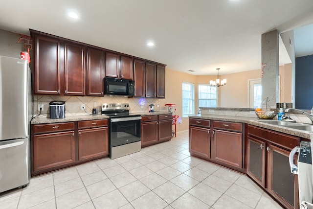 kitchen with light tile patterned floors, stainless steel appliances, tasteful backsplash, a sink, and a chandelier