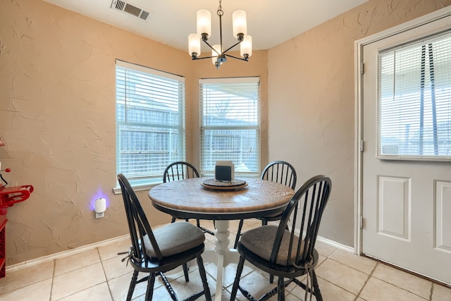 dining space featuring light tile patterned floors, visible vents, a textured wall, an inviting chandelier, and baseboards